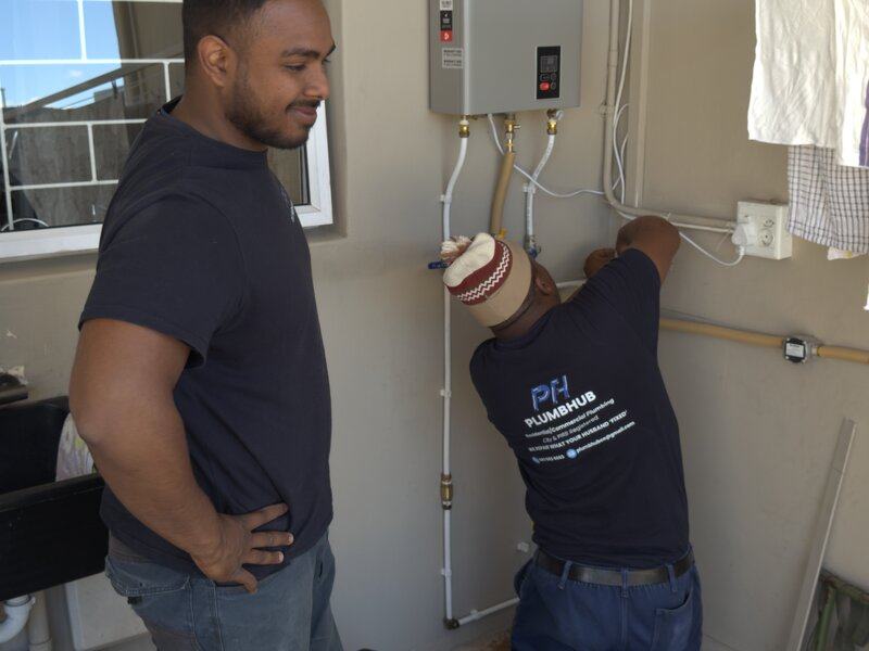 A Plumbhub plumber installing a gas geyser