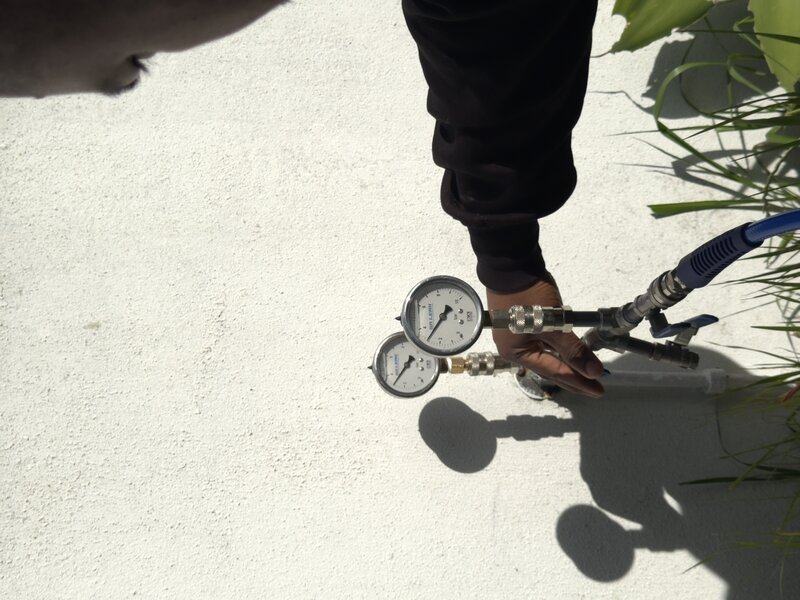 A pressure gauge connected to a water line during testing