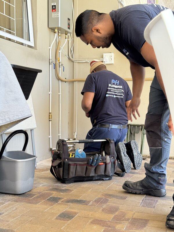 Plumbhub plumbers with their tools at a geyser installation